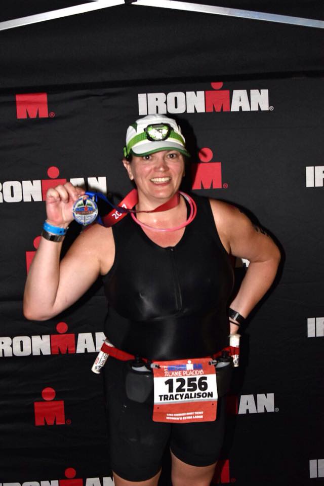 Tracy Ruggiero posing with medal at Ironman Lake Placid in 2017