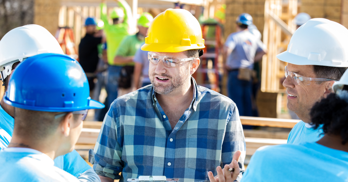 Man on construction site talking to group (Tips for Working Construction in Hot Weather)